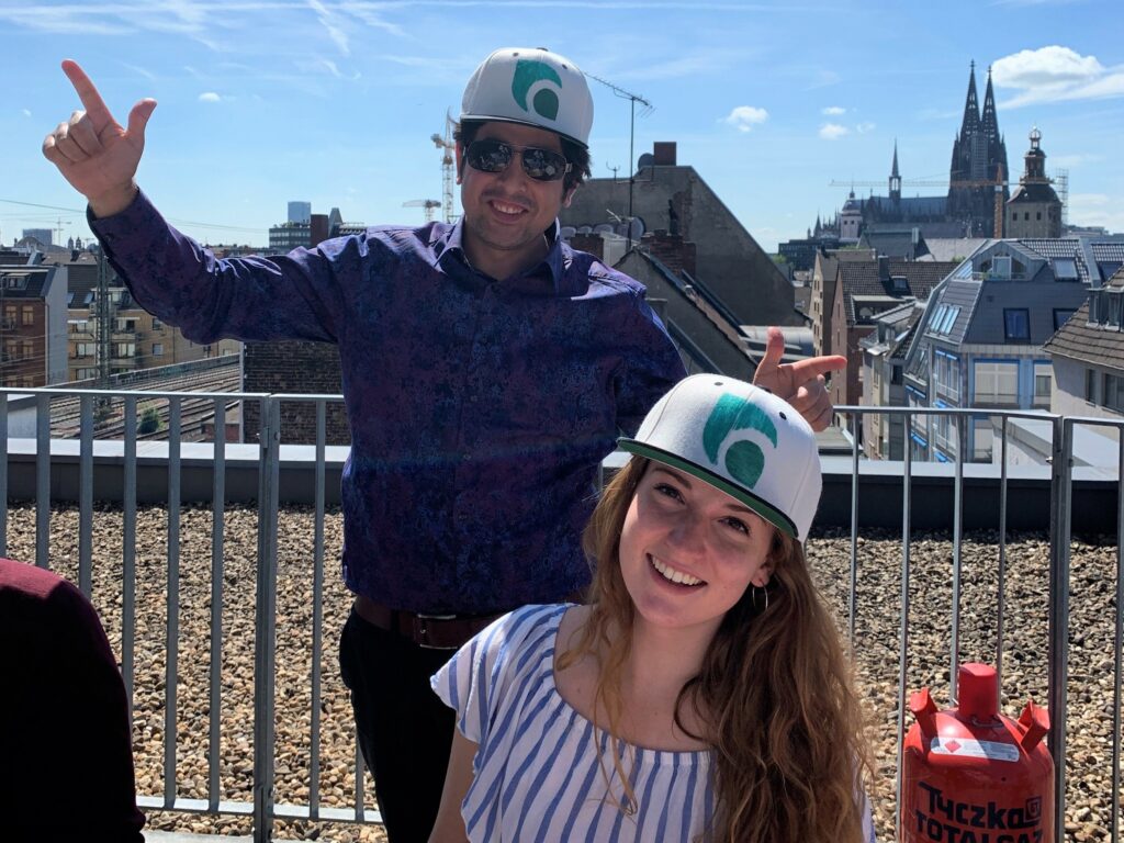 Zwei Mitarbeiter von Honestly mit gebrandeten Caps beim Grillen