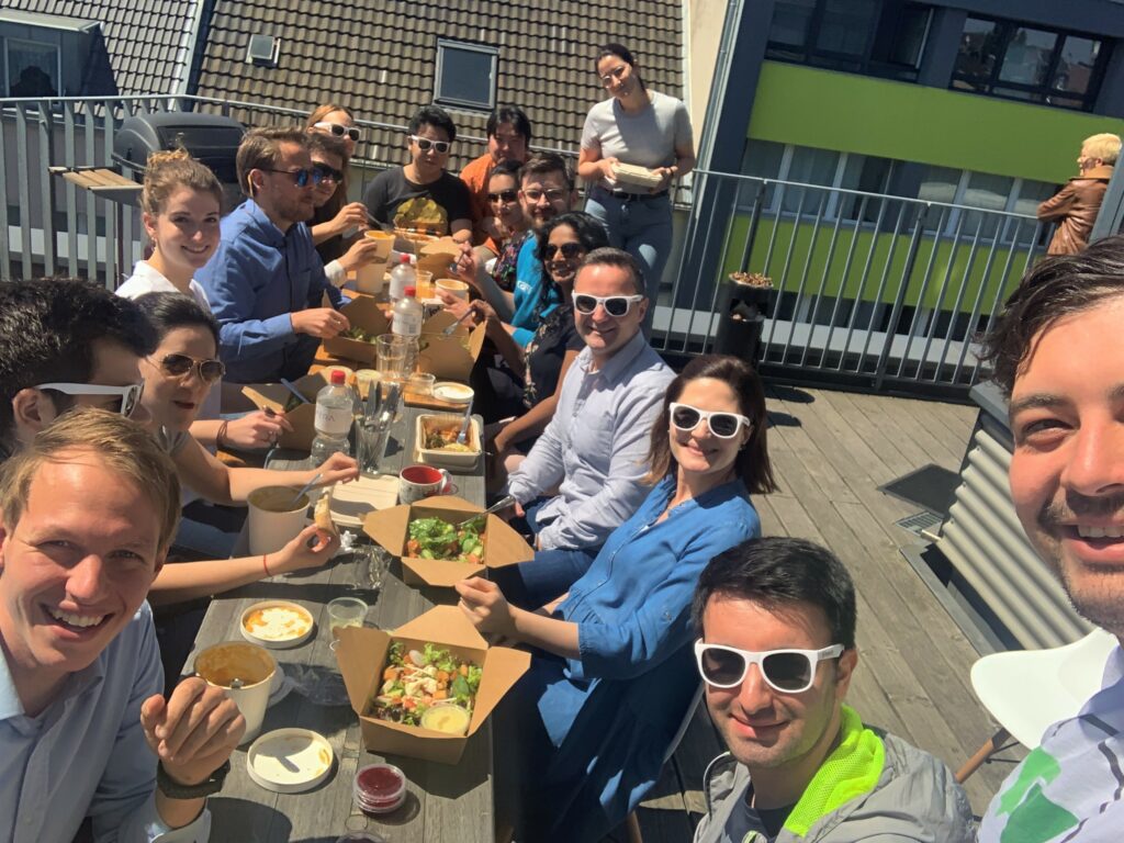 Mehrere Honestly-Mitarbeiter sitzen an einem großen Tisch beim Mittagessen