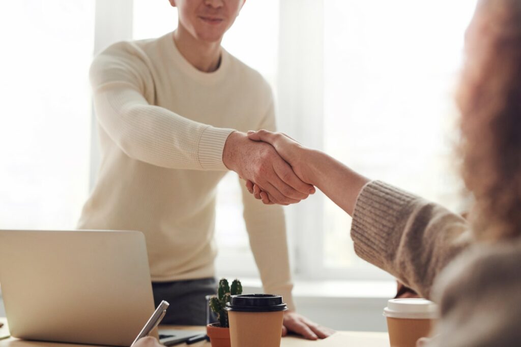 Mann heißt neuen Mitarbeiter mit Handshake willkommen