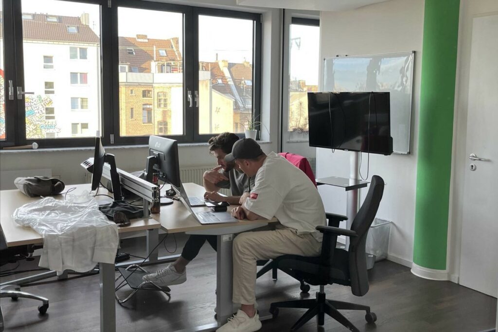 Zwei konzentrierte Honestly Mitarbeiter sitzen gemeinsam am Schreibtisch und arbeiten zusammen