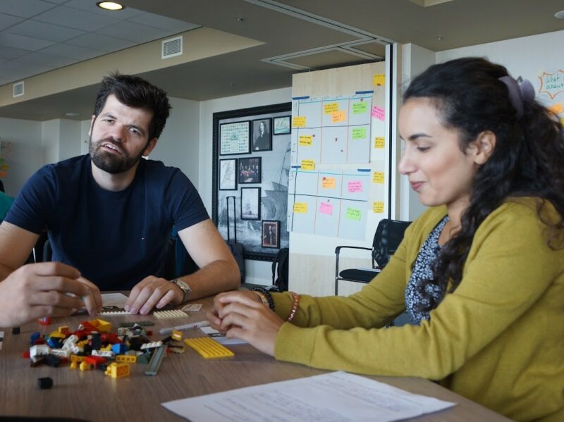 Zwei Honestly Mitarbeiter sitzen gemeinsam am Schreibtisch und arbeiten zusammen kreativ an einem Projekt
